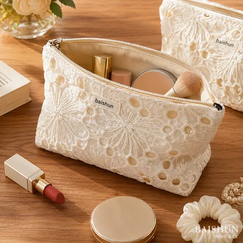 Lace overlay zipper cosmetic pouch opened to show makeup inside